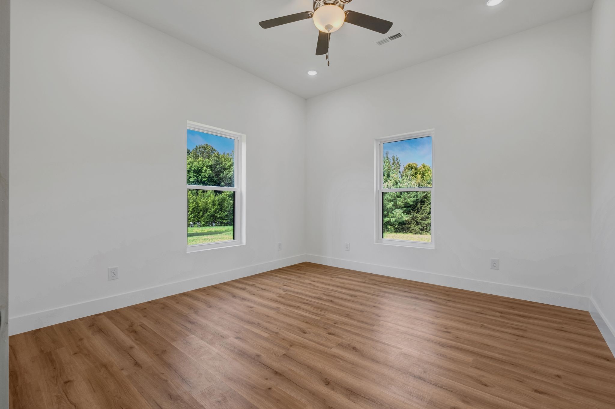 5050 Richards Road Adams, TN 37010 - Photo 25 of 52 an empty room with wooden floor chandelier fan and windows