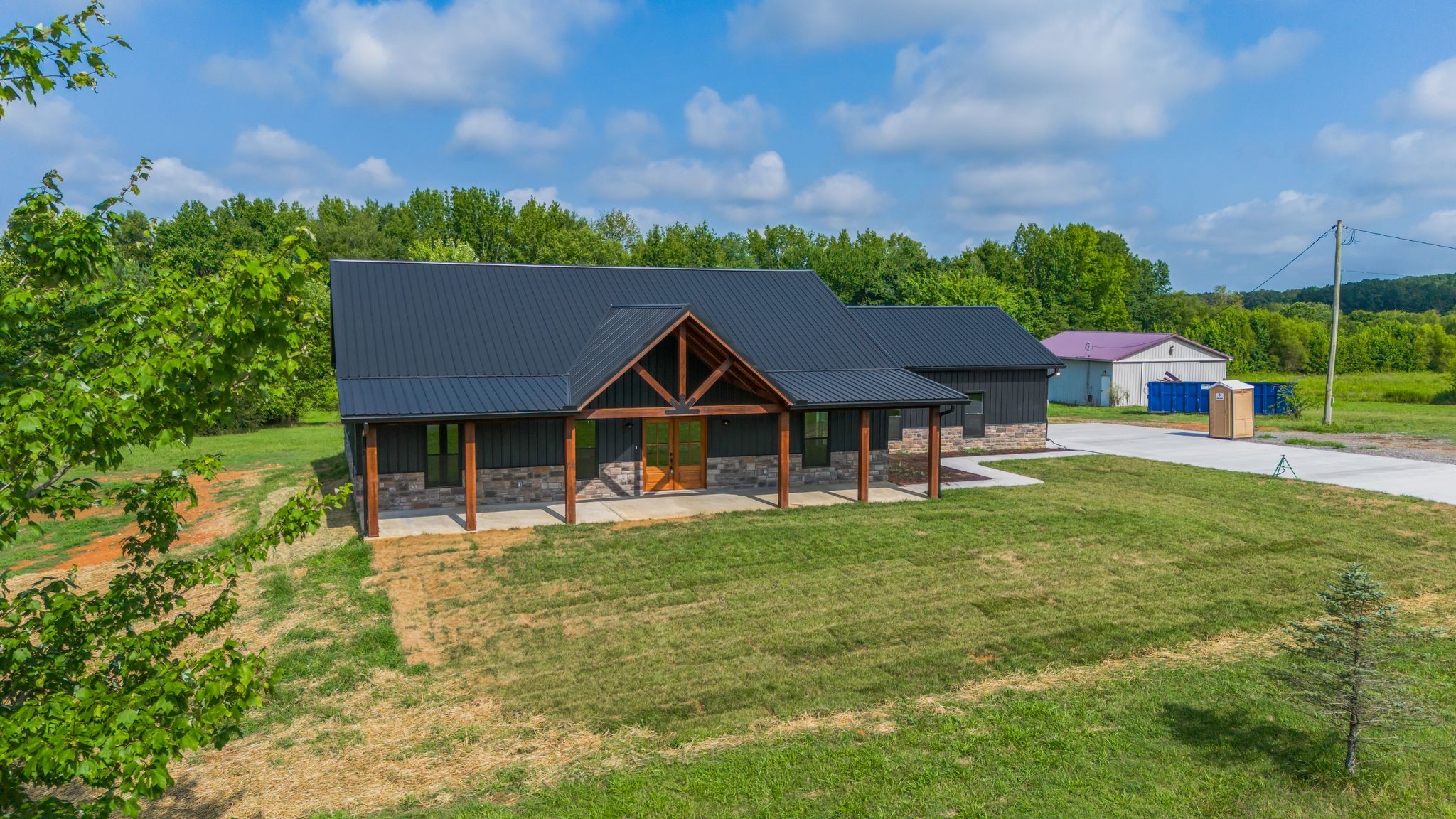 5050 Richards Road Adams, TN 37010 - Photo 35 of 52 a view of a house with a big yard potted plants and large tree