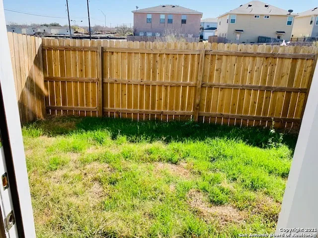 a view of a backyard with wooden fence