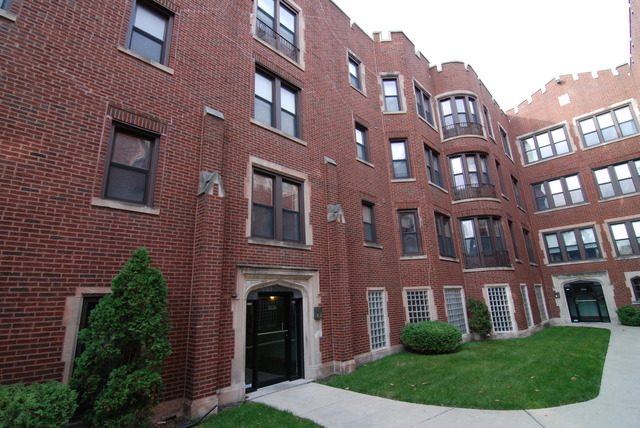 1938 East 74th Street, Unit 3 Chicago, IL 60649 - Photo 1 of 10 a view of a brick building next to a yard