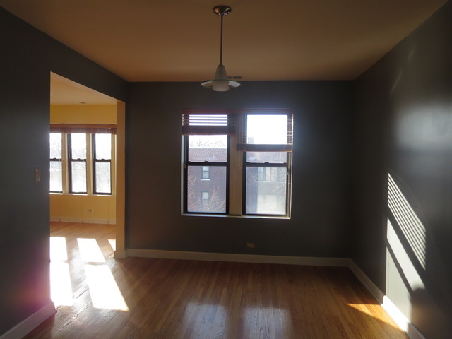 1938 East 74th Street, Unit 3 Chicago, IL 60649 - Photo 5 of 10 a view of an empty room with wooden floor and a window