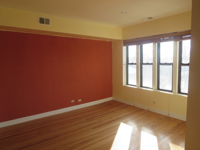 1938 East 74th Street, Unit 3 Chicago, IL 60649 - Photo 6 of 10 a view of empty room with wooden floor and fan