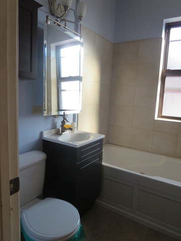 1938 East 74th Street, Unit 3 Chicago, IL 60649 - Photo 8 of 10 a bathroom with a sink a toilet a window and mirror
