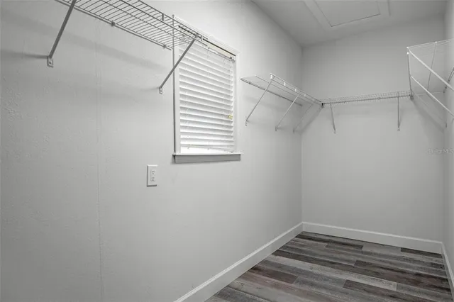 a view of a hallway with wooden floor and closet