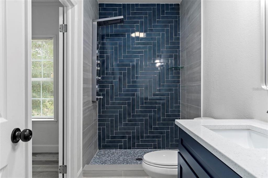 8192 Fort Dade Avenue Brooksville, FL 34601 - Photo 19 of 34 a bathroom with a granite countertop toilet a sink a mirror and shower