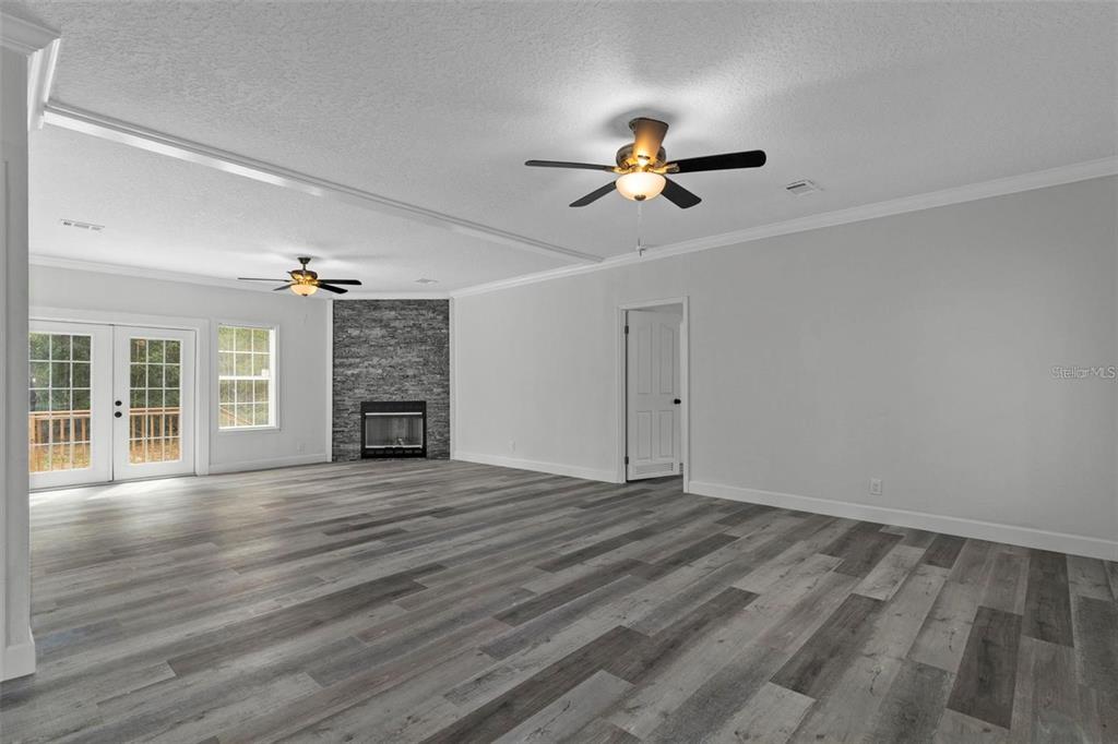 8192 Fort Dade Avenue Brooksville, FL 34601 - Photo 3 of 34 a view of an empty room with wooden floor fireplace and a window