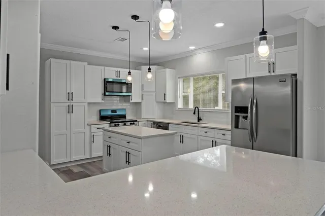 a kitchen with stainless steel appliances a refrigerator sink and stove