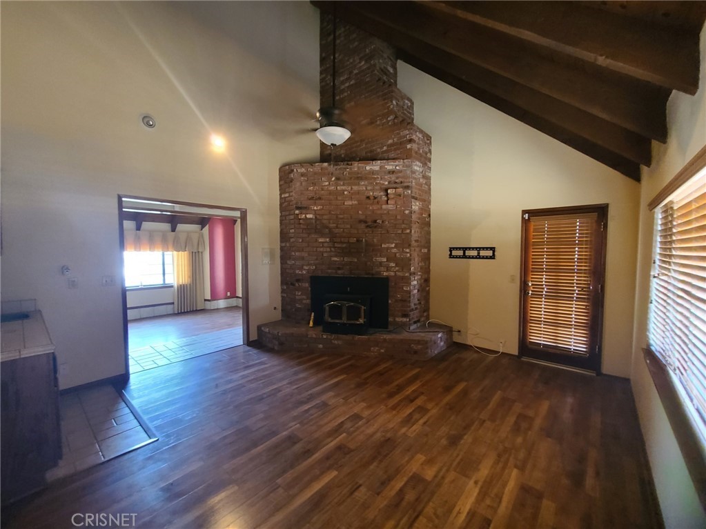 20090 Modoc Road Apple Valley, CA 92308 - Photo 14 of 23 a view of an empty room with wooden floor fireplace and a window