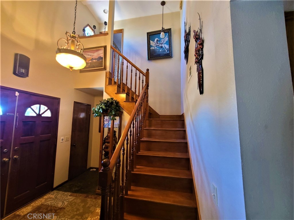 20090 Modoc Road Apple Valley, CA 92308 - Photo 10 of 23 a view of staircase with lots of frames on wall and a chandelier
