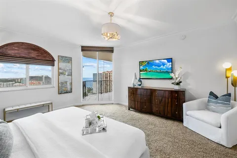 a living room with furniture a flat screen tv and a chandelier