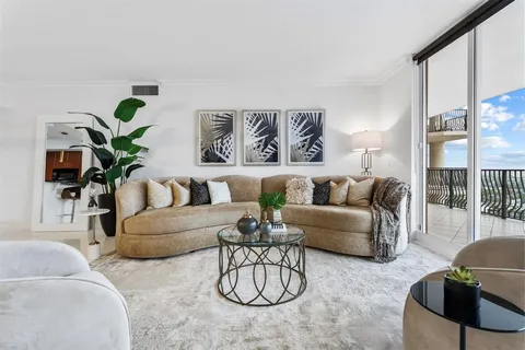 a living room with furniture potted plant and a large window
