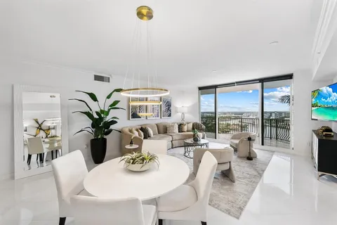 a living room with furniture potted plant and a large window