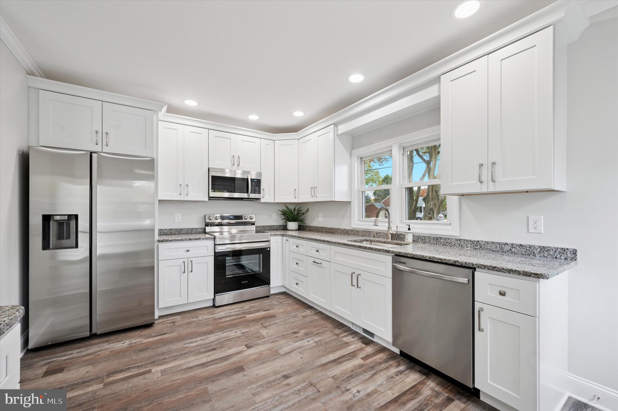1721 Naamans Creek Road Upper Chichester, PA 19061 - Photo 2 of 33 a kitchen with granite countertop white cabinets and stainless steel appliances