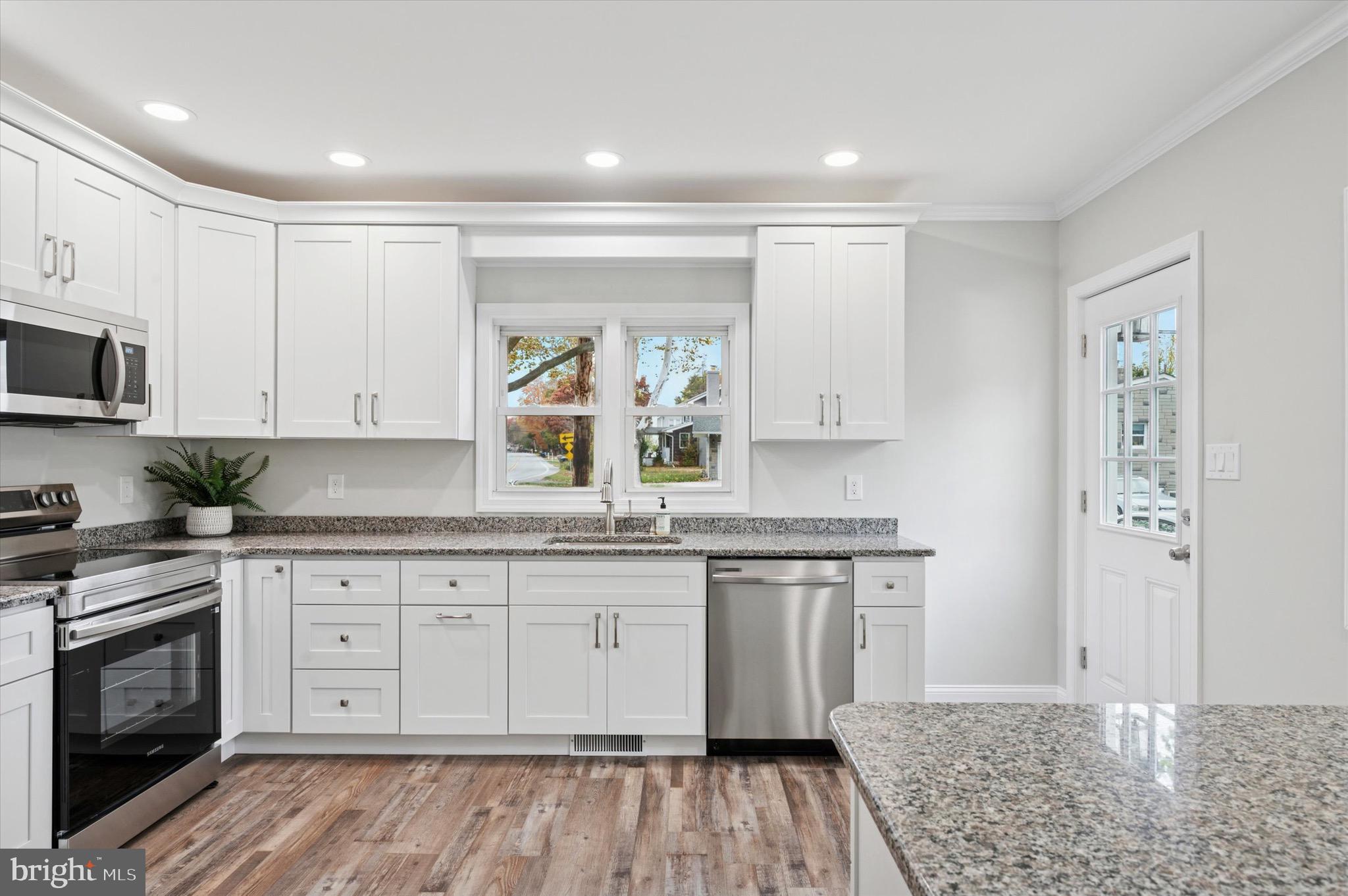 1721 Naamans Creek Road Upper Chichester, PA 19061 - Photo 4 of 33 a kitchen with stainless steel appliances granite countertop a stove a sink and a refrigerator