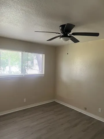 an empty room with a window and a ceiling fan