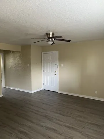 a view of an empty room with wooden floor