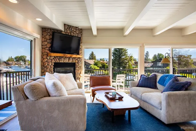 a living room with furniture a flat screen tv and a floor to ceiling window