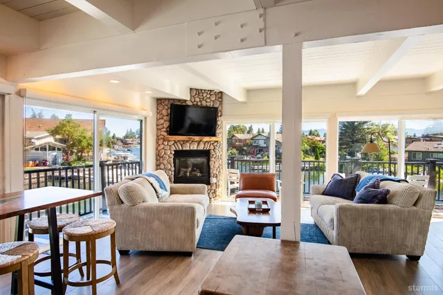 a living room with furniture a fireplace and a floor to ceiling window