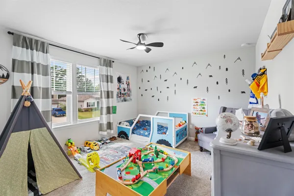 a view of a bedroom with baby crib and furniture