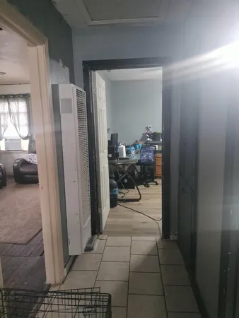 a view of a hallway and a livingroom with furniture