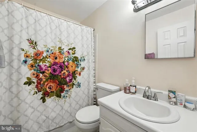 a bathroom with a toilet sink and mirror
