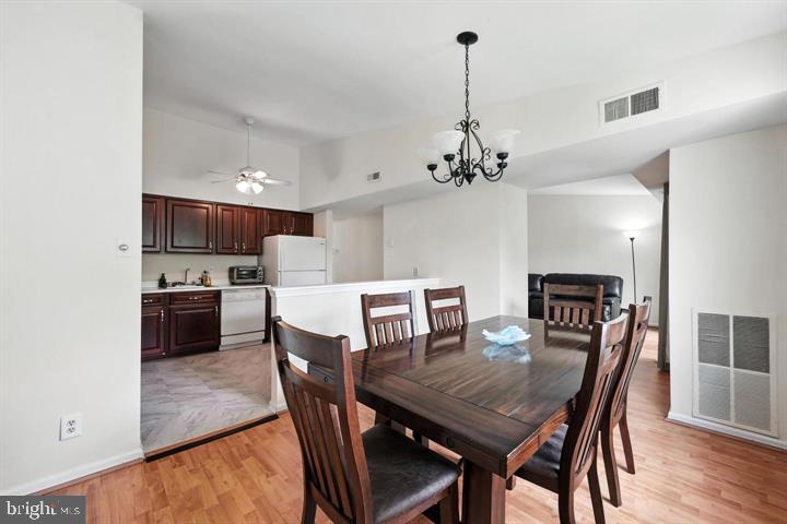 20315 Beaconfield Terrace, Unit 202 Germantown, MD 20874 - Photo 9 of 25 a view of a dining room with furniture and wooden floor