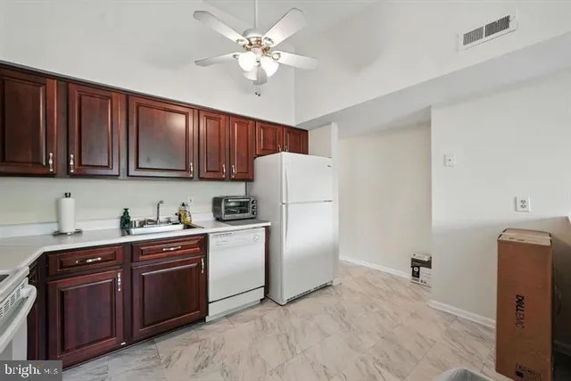 a kitchen with a refrigerator a stove cabinets and wooden floor