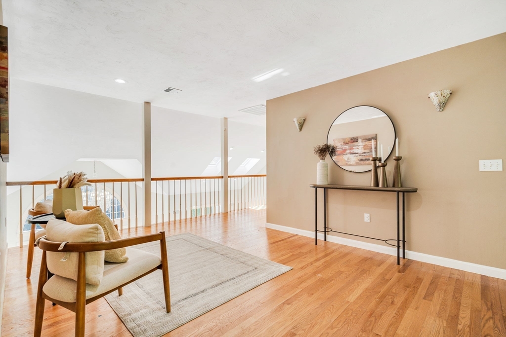 153 Walpole Street Dover, MA 02030 - Photo 16 of 42 a view of a hallway with wooden floor and iron stairs