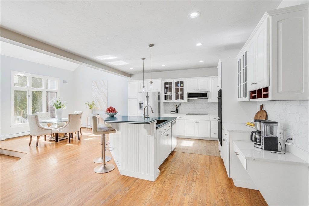 153 Walpole Street Dover, MA 02030 - Photo 7 of 42 a kitchen with stainless steel appliances kitchen island granite countertop a stove a sink a refrigerator and white cabinets with wooden floor