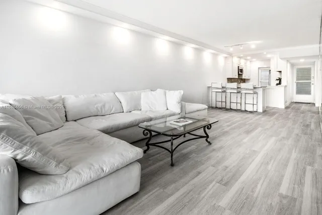 a living room with furniture and kitchen view