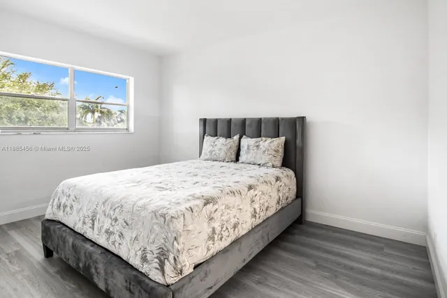 a bed sitting in a bedroom next to a window