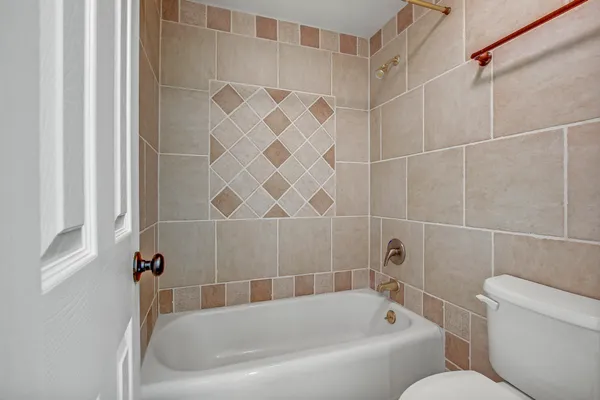 a bathroom with toilet next to a tub