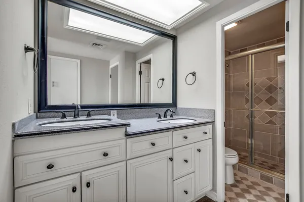 a bathroom with a granite countertop sink a toilet and a mirror