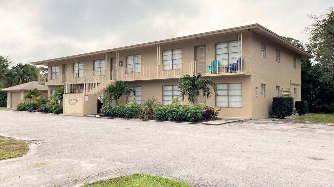 4606 Southeast Binnacle Way, Unit 1 Stuart, FL 34997 - Photo 1 of 5 a front view of a house with a yard and potted plants