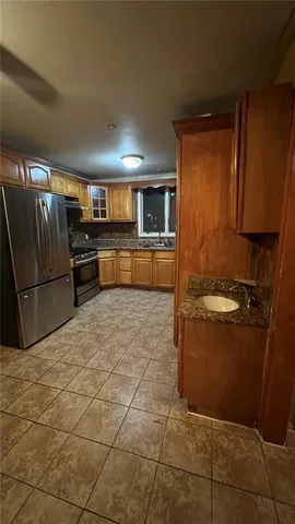 a kitchen with granite countertop a refrigerator and a stove top oven