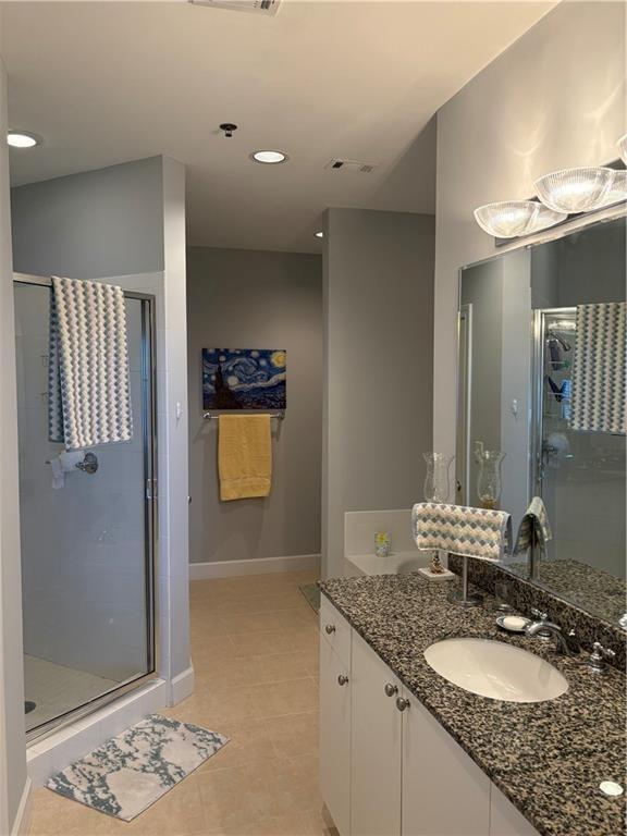 2626 Peachtree Road Northwest, Unit 704 Atlanta, GA 30305 - Photo 11 of 23 a bathroom with a granite countertop sink and a mirror
