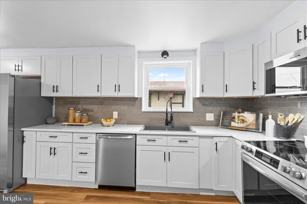 a kitchen with granite countertop a sink a stove and cabinets