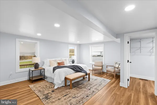 a bedroom with a bed and wooden floor