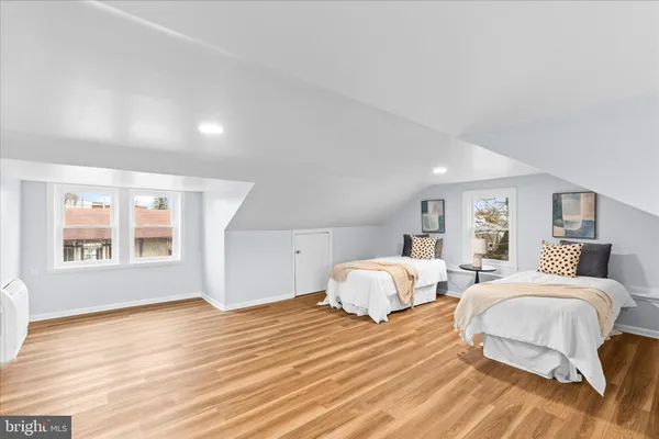 a spacious bedroom with two beds and wooden floor