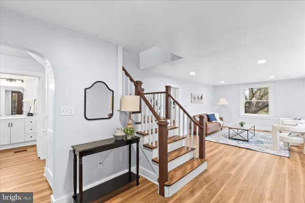 a living room with lots of white furniture and a chandelier