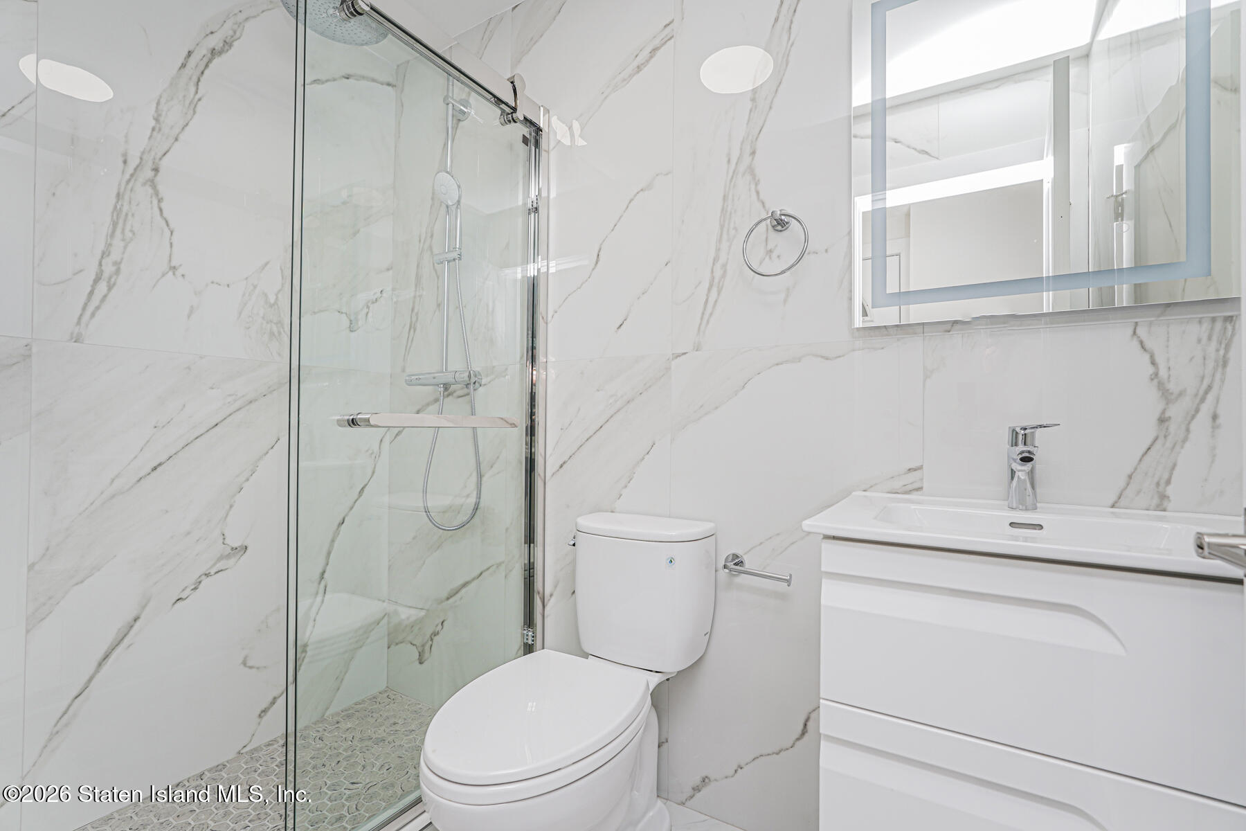 54 Cedarcliff Road Staten Island, NY 10301 - Photo 42 of 49 a bathroom with a toilet sink vanity and shower