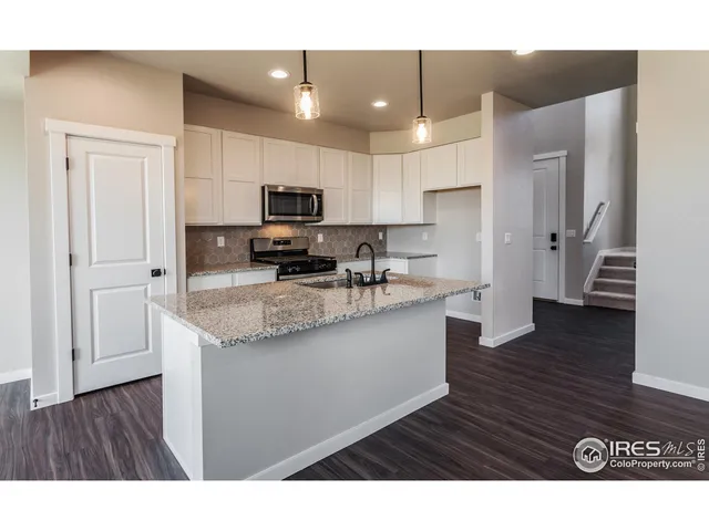 a open kitchen with kitchen island a sink dishwasher a refrigerator and a stove with wooden floor