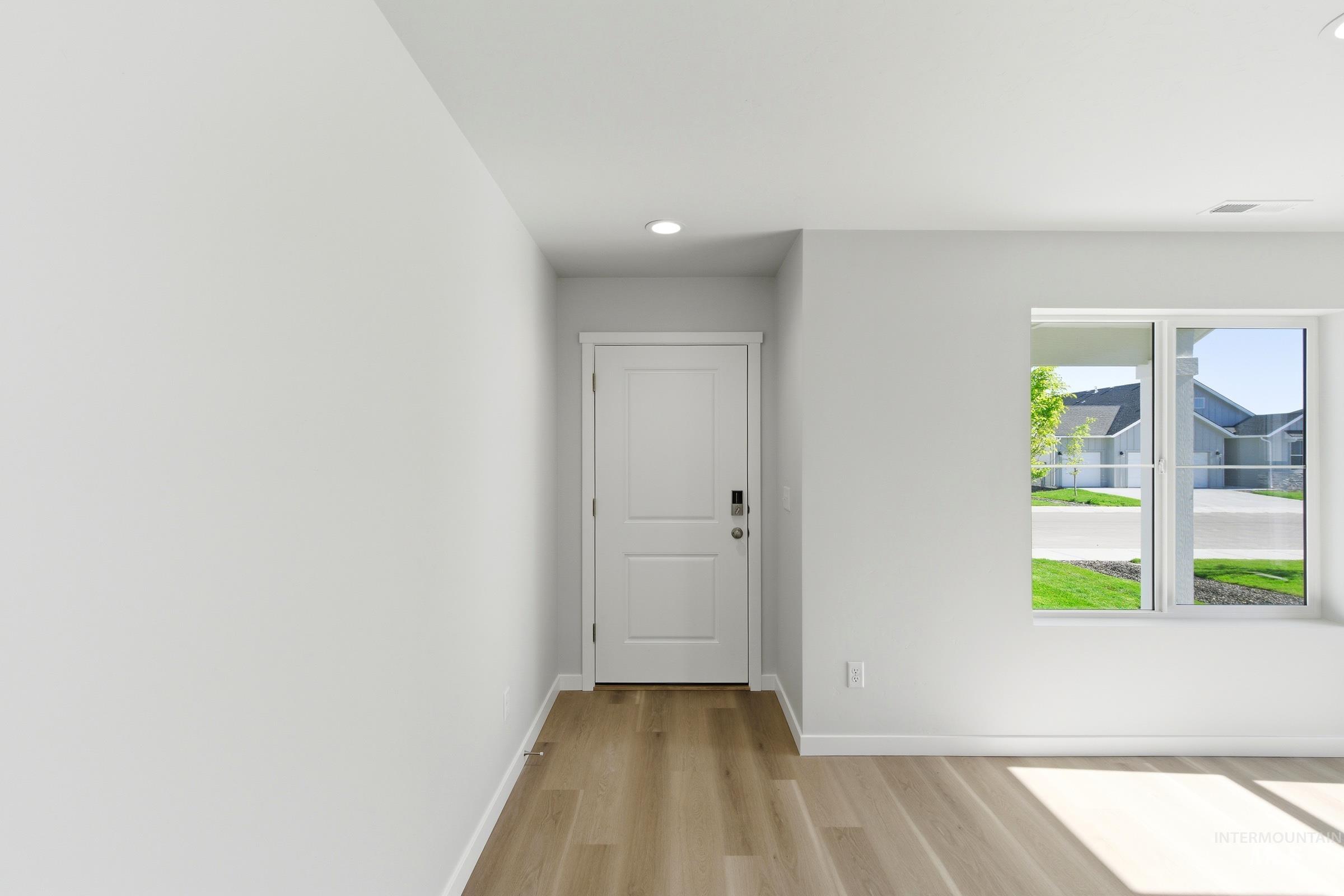 13677 Redway Court Caldwell, ID 83607 - Photo 2 of 35 Entryway featuring wood-finish flooring, a white paneled door with contemporary hardware, recessed ceiling lighting, a large window, and white baseboards