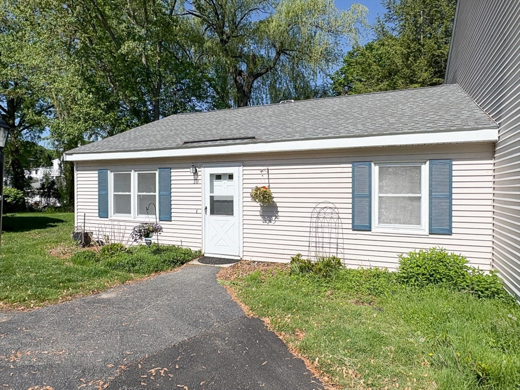 103 Main Street, Unit 10 Pepperell, MA 01463 - Photo 21 of 22 a front view of a house with a yard and potted plants