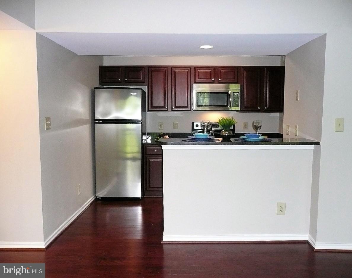 3903 Penderview Drive, Unit 1535 Fairfax, VA 22033 - Photo 8 of 36 a kitchen with a sink a refrigerator freezer a microwave and cabinets