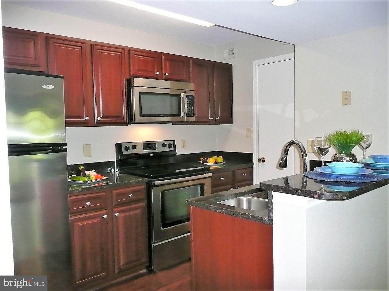 3903 Penderview Drive, Unit 1535 Fairfax, VA 22033 - Photo 9 of 36 a kitchen with stainless steel appliances granite countertop a stove a sink and a microwave
