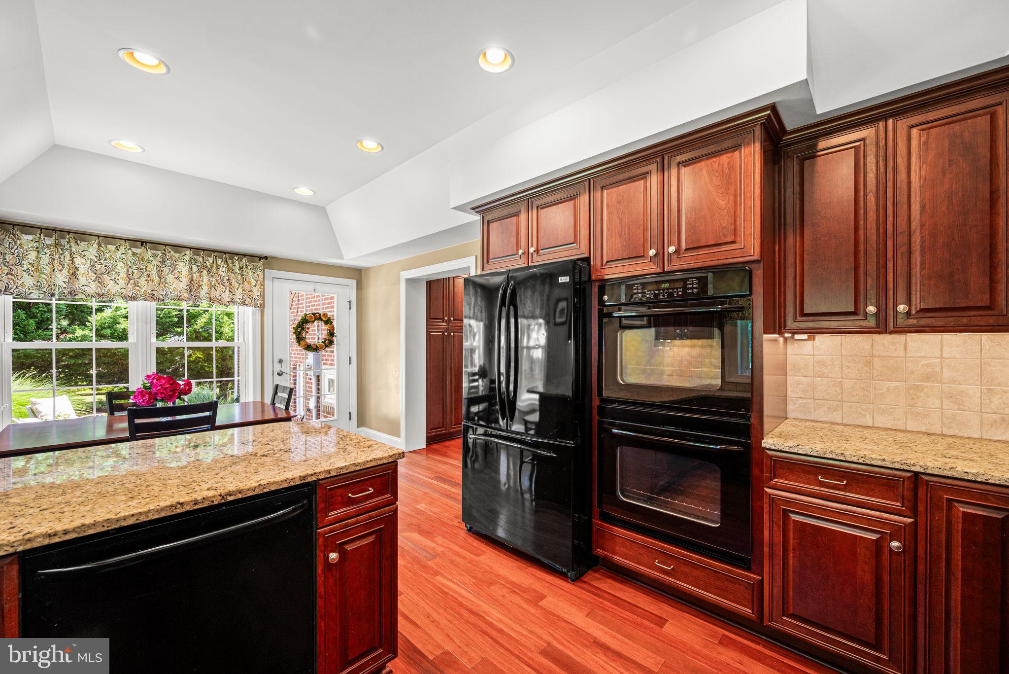107 Lombardy Drive Wallingford, PA 19086 - Photo 16 of 36 a kitchen with granite countertop a refrigerator cabinets and wooden floor