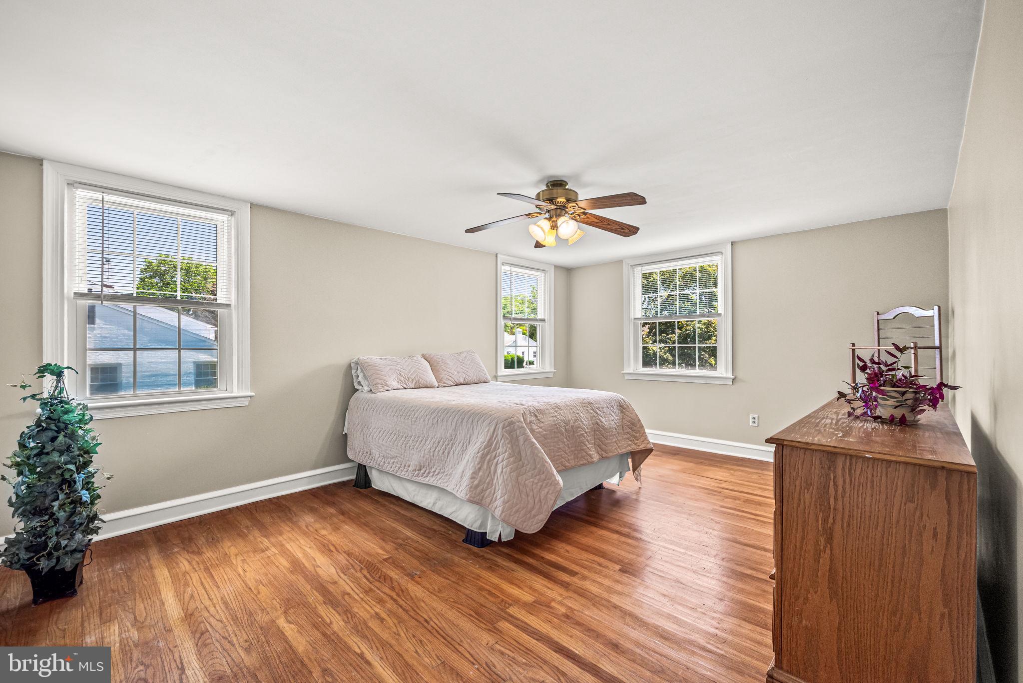 107 Lombardy Drive Wallingford, PA 19086 - Photo 23 of 36 a spacious bedroom with a bed and wooden floor