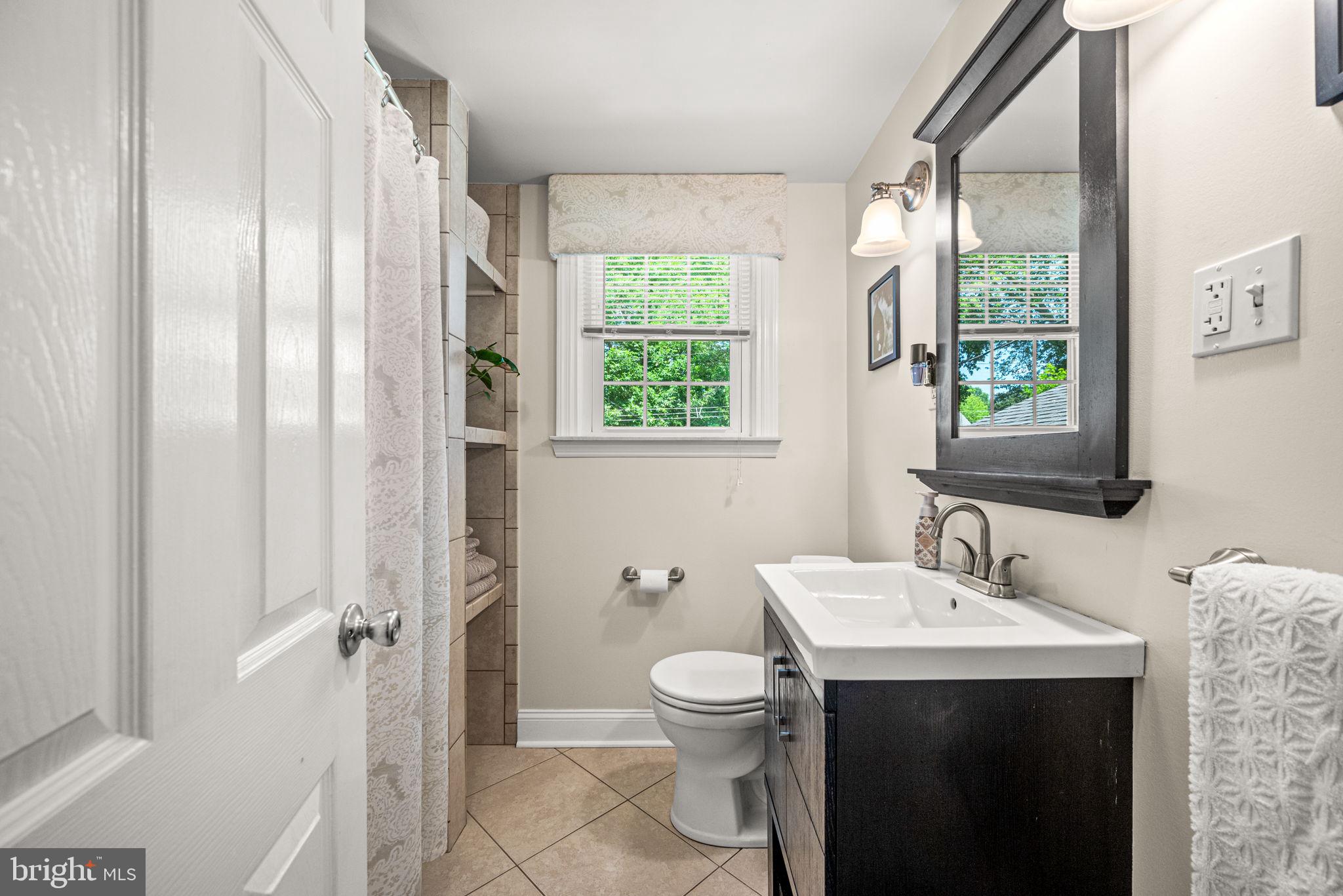 107 Lombardy Drive Wallingford, PA 19086 - Photo 24 of 36 a bathroom with a toilet sink and mirror