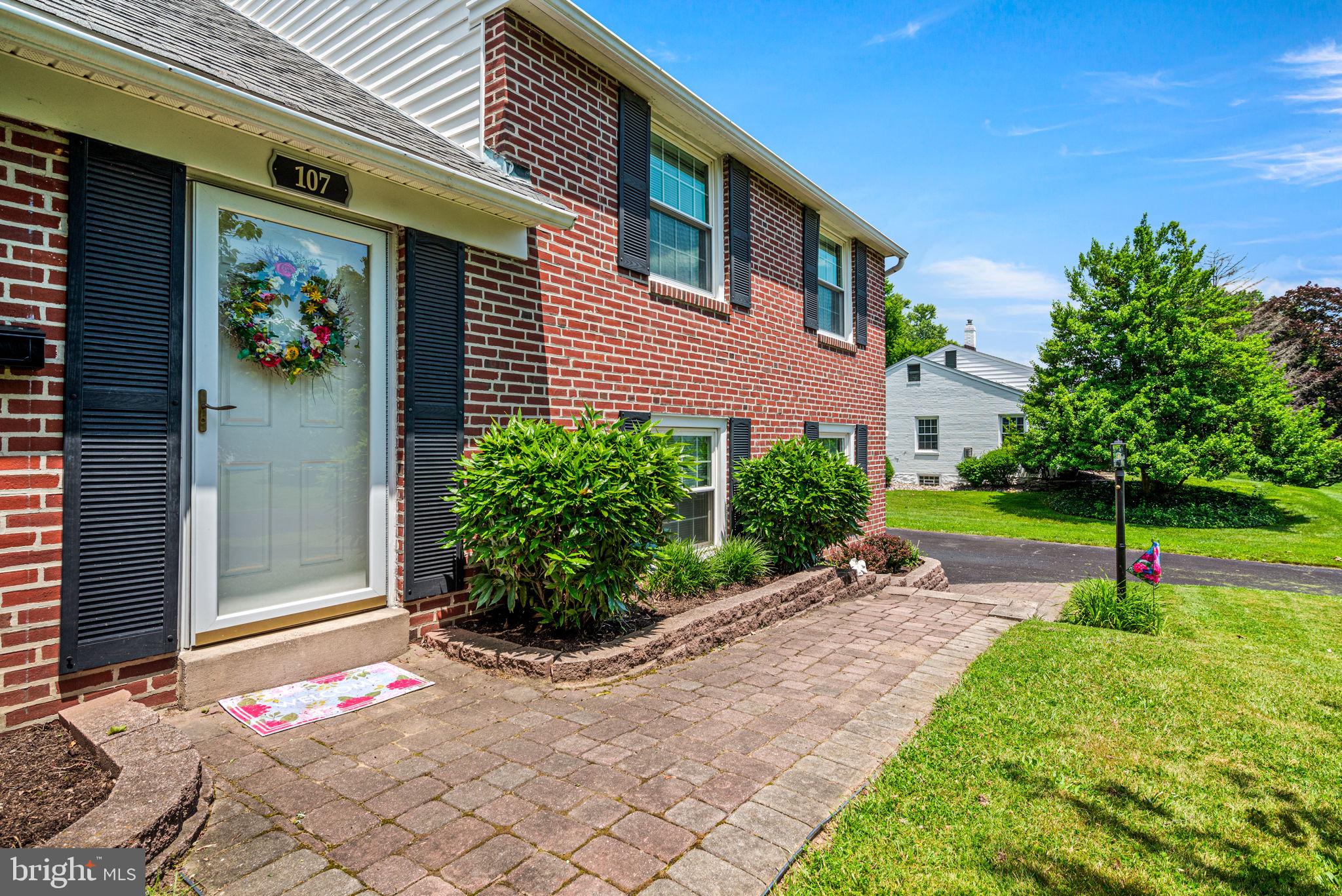 107 Lombardy Drive Wallingford, PA 19086 - Photo 3 of 36 a view of a backyard with plants and brick wall